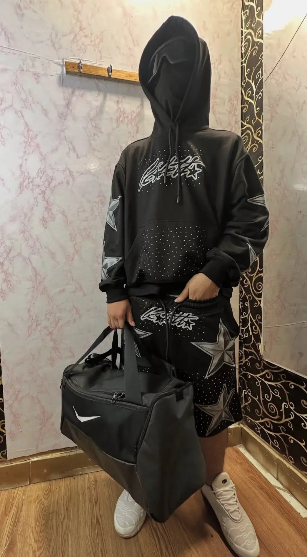 Hombre usando set Dawn Star Drip negro Kaletta con sneakers en look nocturno streetwea